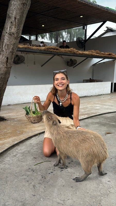 Ane Eline Larsen petting a capybara at a café